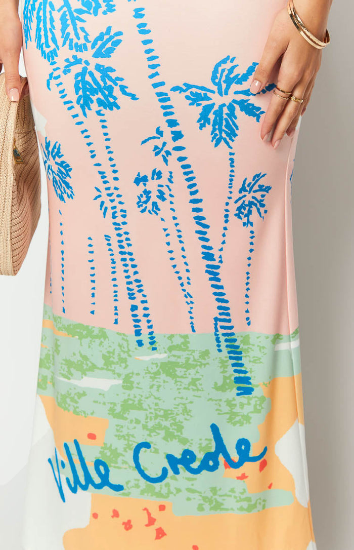 Side view of a strapless bodycon maxi dress with blue palm print on peach and green colour block panels