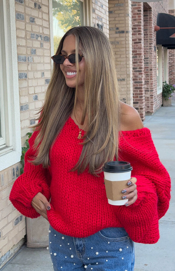 Beginning Boutique Delvey Red Chunky Knit Sweater red chunky knit sweater with a V-neckline worn off-shoulder and voluminous long sleeves