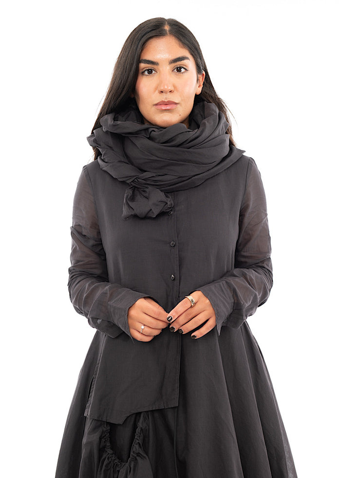 A Model wearing a washed Grey Scarf, wrapped around her neck in a design technique. Paired with a matching bubble dress.