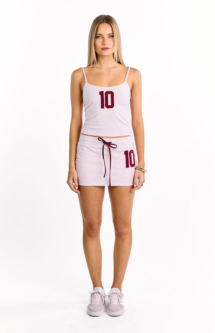 Pink jersey mini skort featuring a dark red drawstring waist and a matching number 10 graphic on the left thigh
