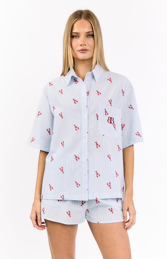 Light blue and white striped pajama shirt with red lobster print, short sleeves, collar, button-front, and chest pocket with red BB logo
