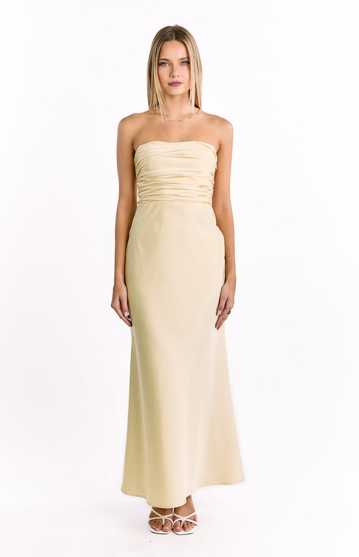 Pale yellow strapless maxi dress with a horizontally ruched bodice and a long, flowing skirt