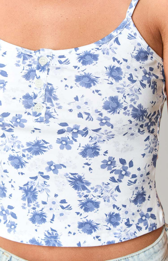 Close-up of the white singlet with blue floral print and front button placket