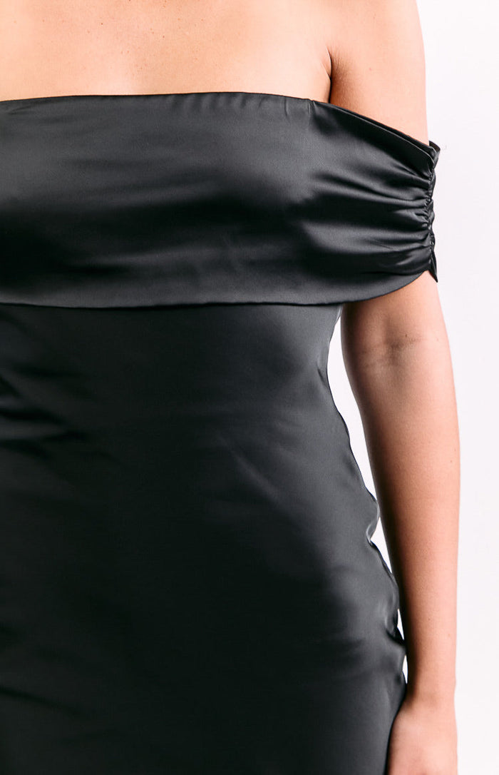 Close-up of the black satin off-shoulder neckline with ruched detail on the side of the maxi dress