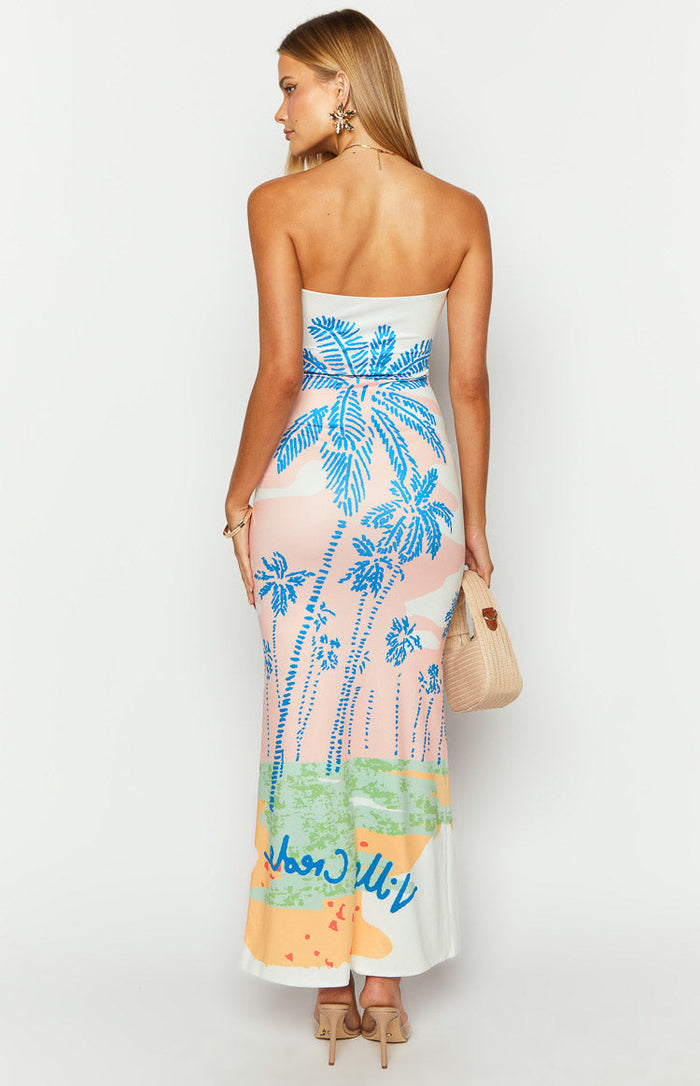 Close-up of the "Ville Crede" blue text graphic and multi-coloured abstract print on a pink palm print maxi dress