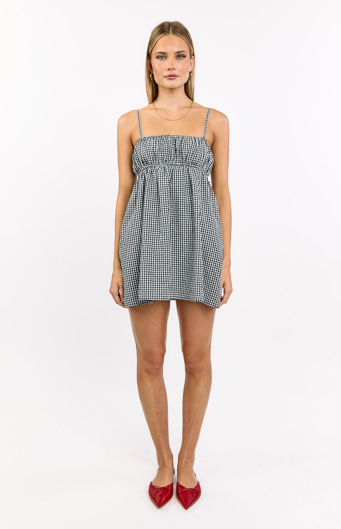 Front view of a black gingham babydoll mini dress with a shirred bodice and thin spaghetti straps