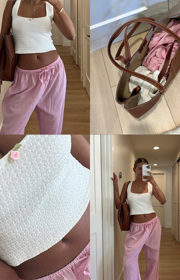 Close-up of the white textured knit crop top with a small pink rose appliqué on the front