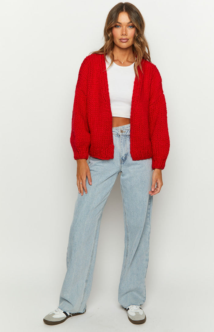 Side view of the red chunky knit cardigan, highlighting its thick texture and oversized balloon sleeves