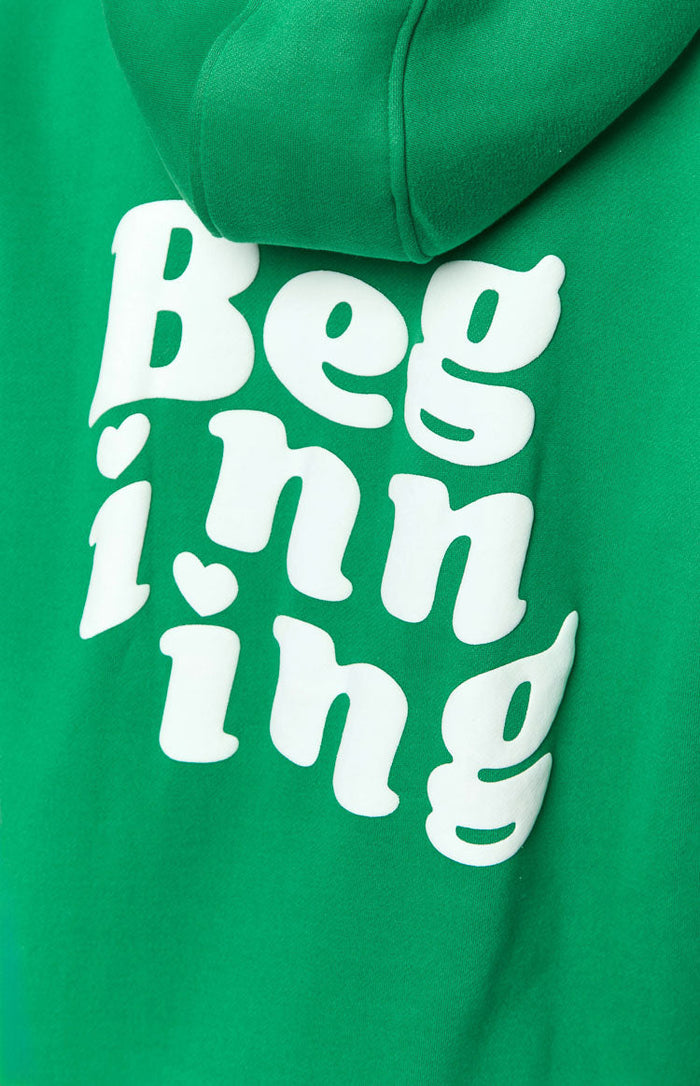 Close-up of the white raised "Beginning" text with heart details on the green hoodie fabric