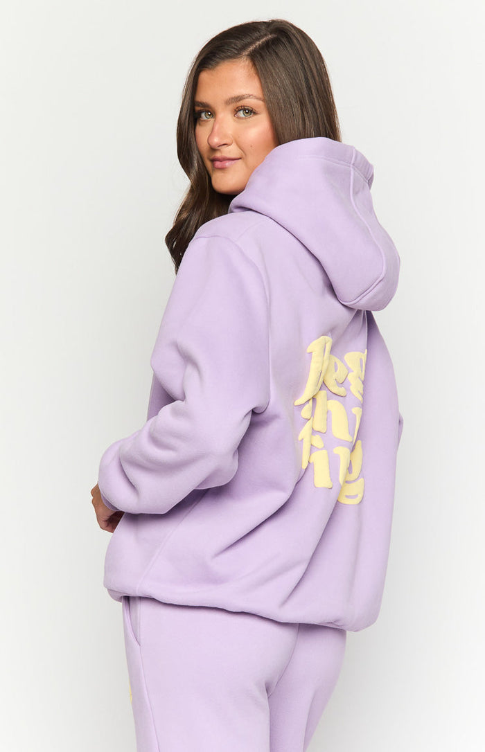 Side view of a lavender purple oversized hoodie with yellow 'Best Thing' graphic text on the back and ribbed cuffs