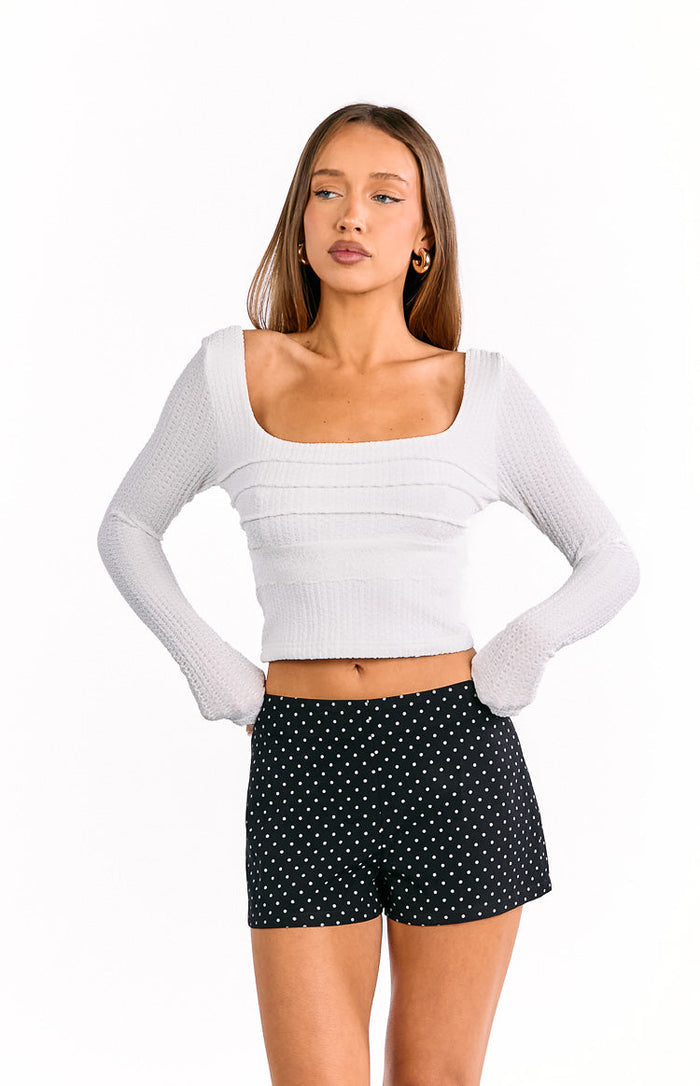 Front view of black high-waisted shorts with small white polka dots