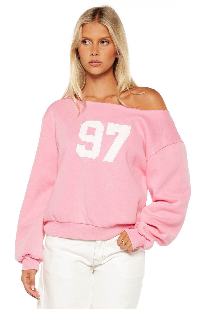 Pink off-shoulder sweater with a white 97 graphic on the front and a raw edge neckline