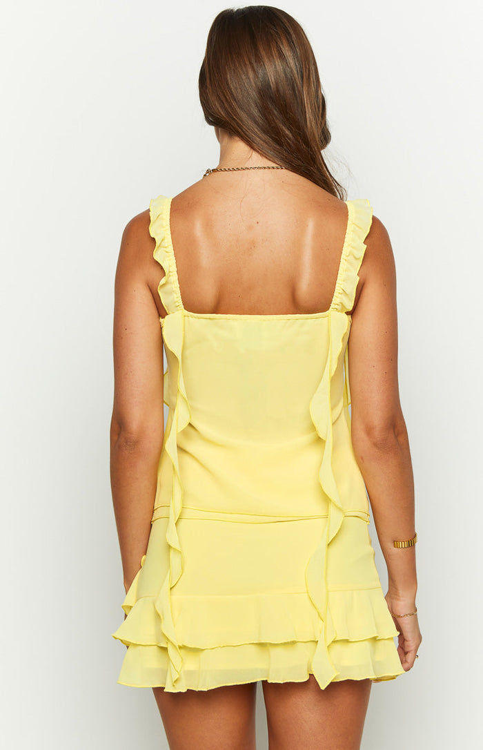 Rear view of a yellow chiffon top featuring a square back neckline, ruffled shoulder straps, and ruffled trim down the back