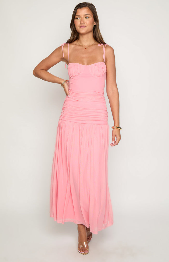 Full-length view of a pink ruched maxi dress with a bustier bodice, tie straps, and a flowing skirt