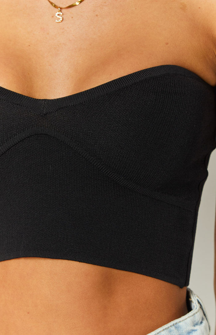 Close-up of the black knit corset top showing the structured bust seams and fine ribbed texture
