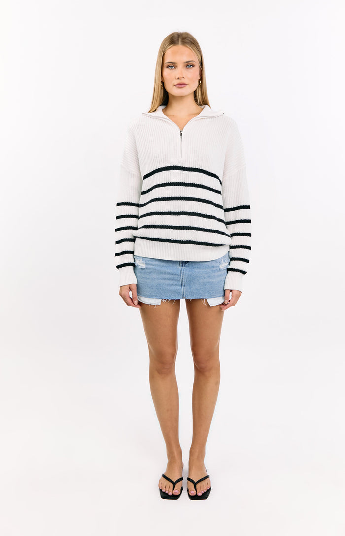 Front view of a cream knit quarter zip jumper with black horizontal stripes and a relaxed, slightly oversized fit