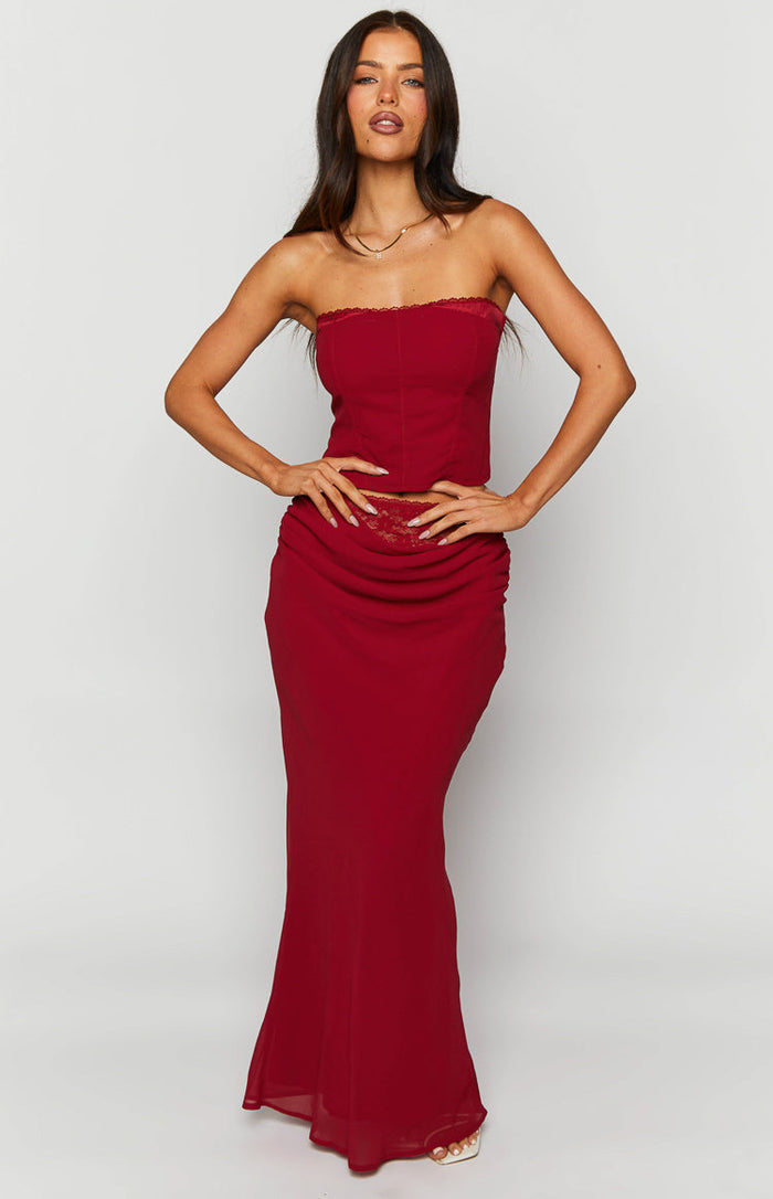 Front view of a crimson rose red maxi skirt with ruched hip detail and delicate lace trim