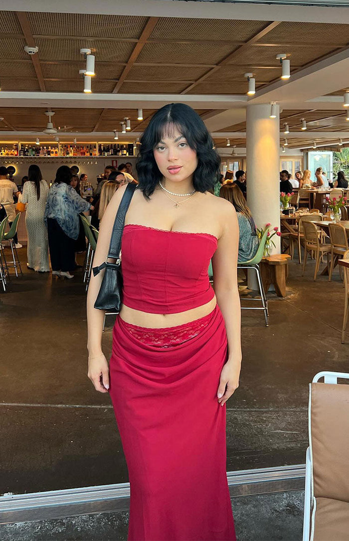 Crimson red maxi skirt with a low-rise draped waist and visible lace trim