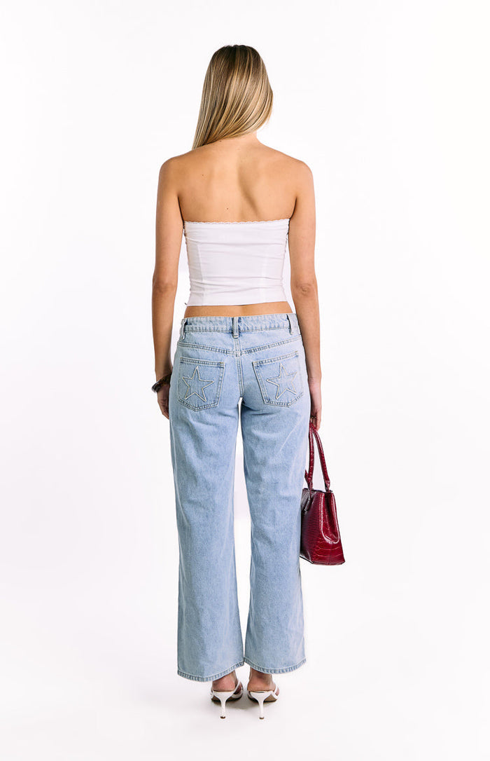 Rear view of a white strapless top with a structured bodice and delicate lace trim along the neckline