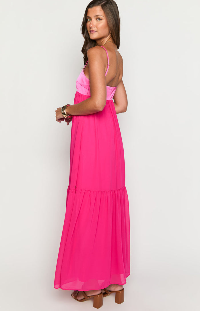 Side view of the hot pink maxi dress with a contrasting pink satin bodice and a tiered maxi skirt