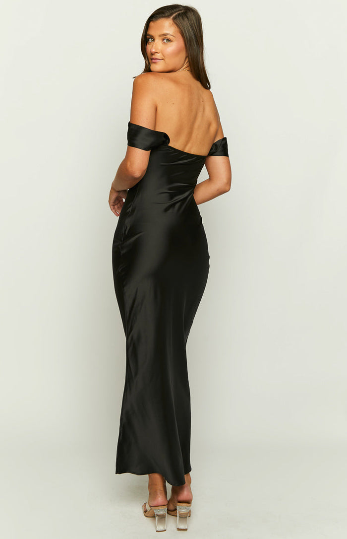 Rear-side view of a black satin off-shoulder maxi dress showing the bare back and fitted skirt