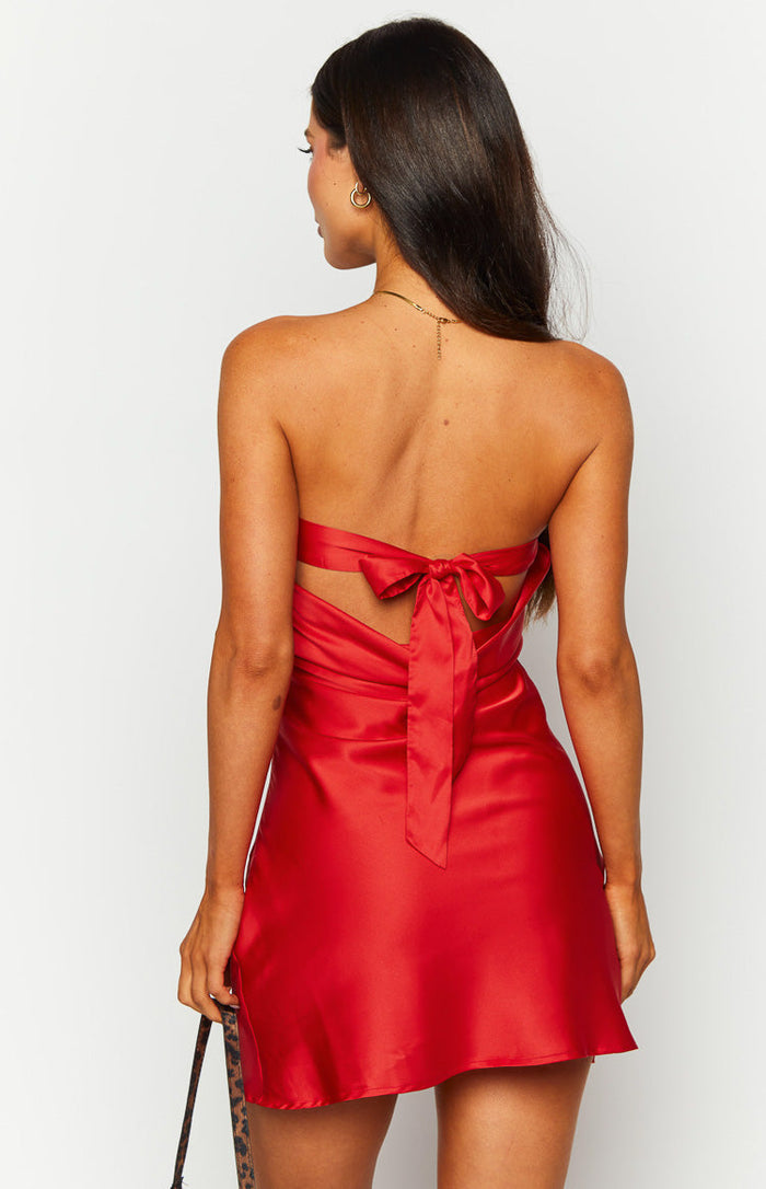 Rear view of a red satin strapless mini dress with a large tie-back bow and cutout detail