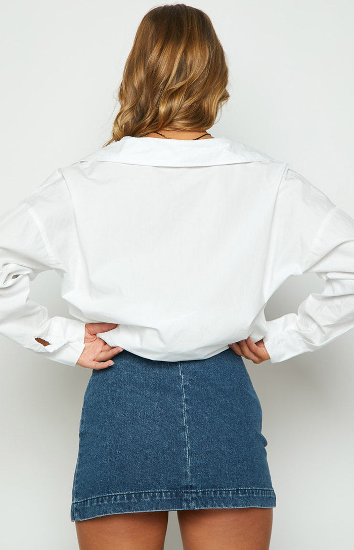 Rear view of a dark blue denim mini skirt with a straight hem and a central vertical seam