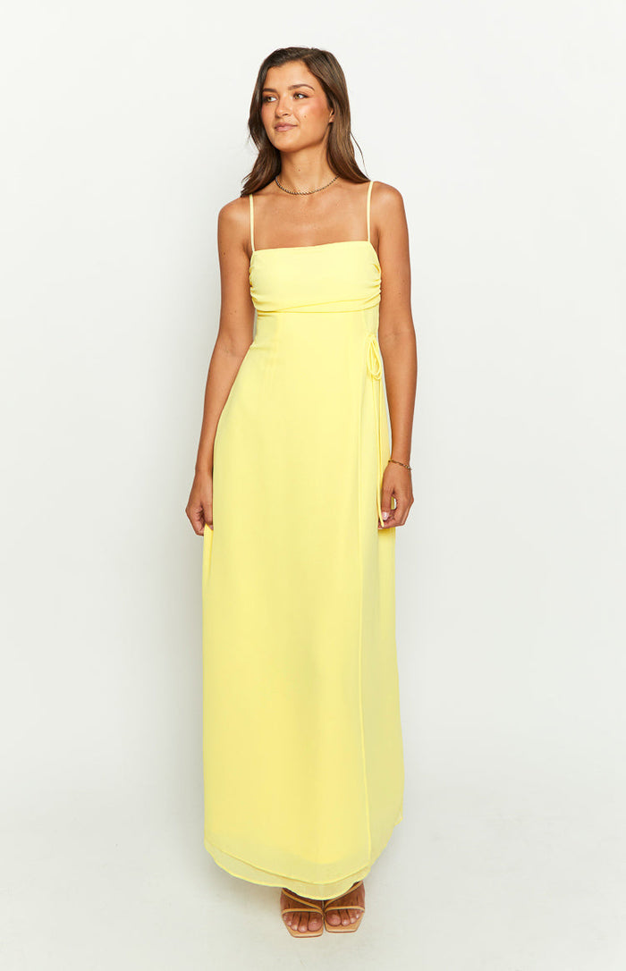 Front view of a yellow maxi dress with a straight neckline, spaghetti straps, and side tie detail
