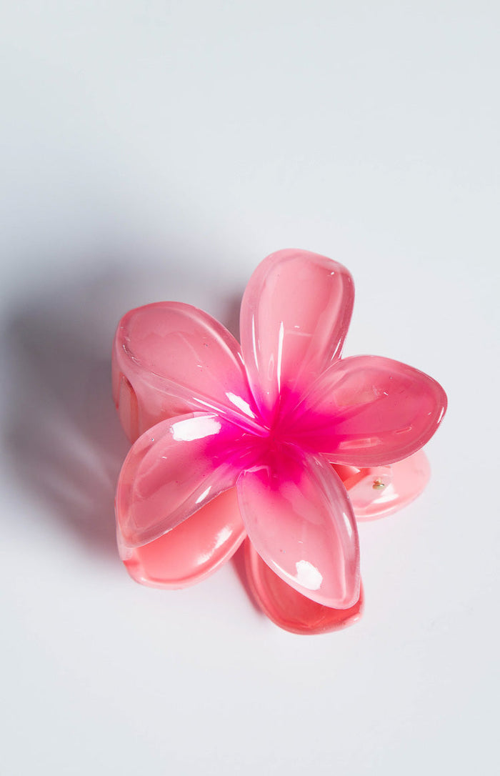 Angled view of a translucent pink frangipani flower clip with a vibrant pink gradient centre