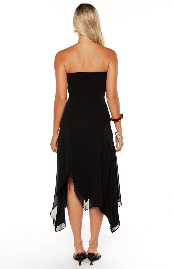 Rear view of a black strapless midi dress showing the hanky hem and flowy skirt