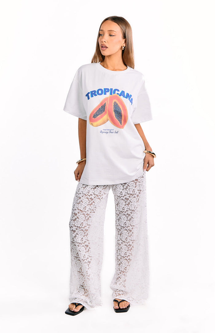 Full length front view of white floral lace wide-leg pants with a sheer finish