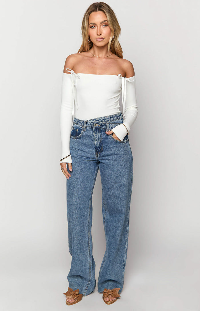 Blue wide-leg jeans with a distinctive uneven crossover waist and relaxed fit