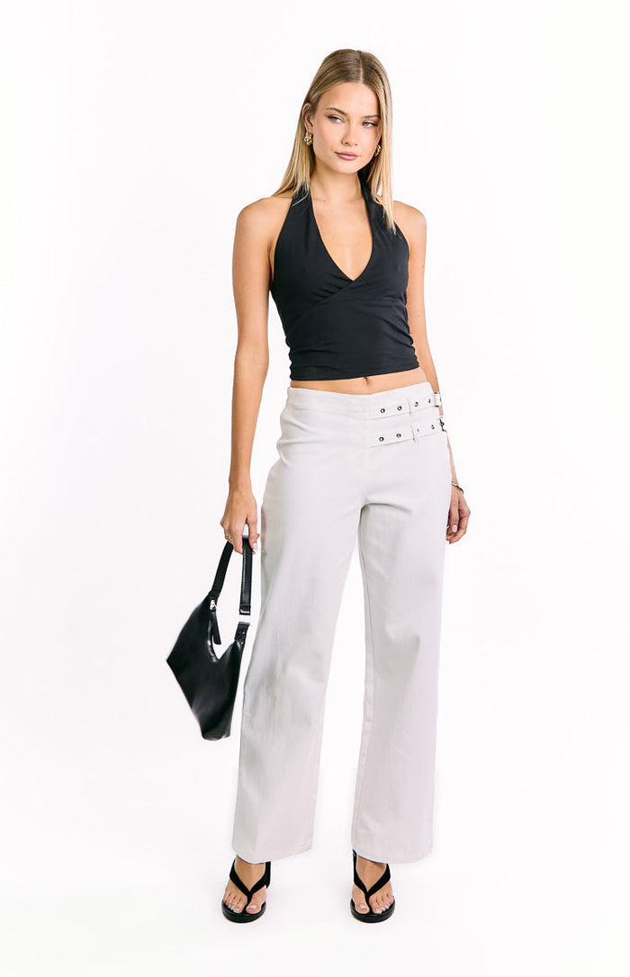 Off-white wide-leg pants with double buckle detailing on the hips