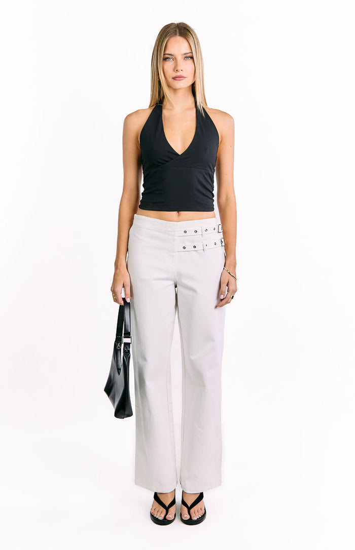 Front view of off white straight leg pants with double buckle straps on each hip