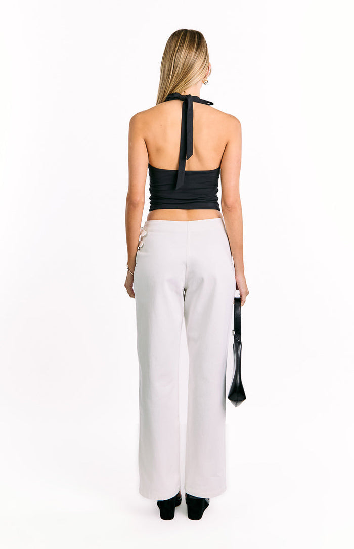 Rear view of off-white wide-leg pants with buckle details on the side of the waist