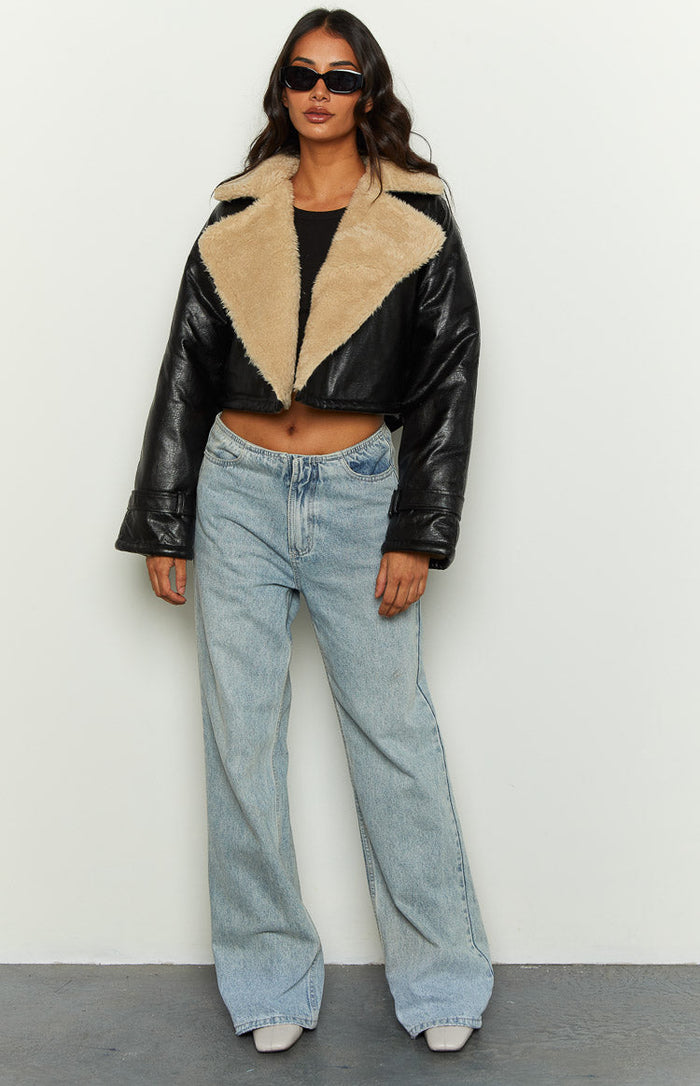 Open black cropped faux leather jacket with wide tan faux shearling lapels and wide long sleeves