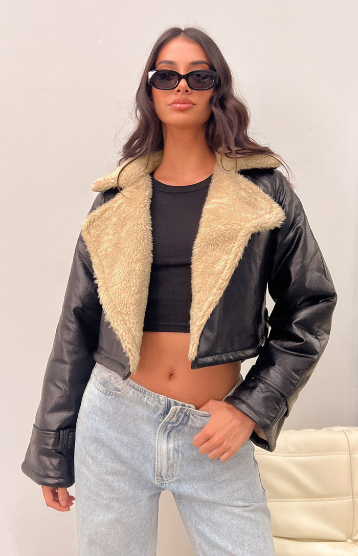 Cropped black faux leather jacket with wide cream faux shearling collar and lapels, showing sleeve cuffs
