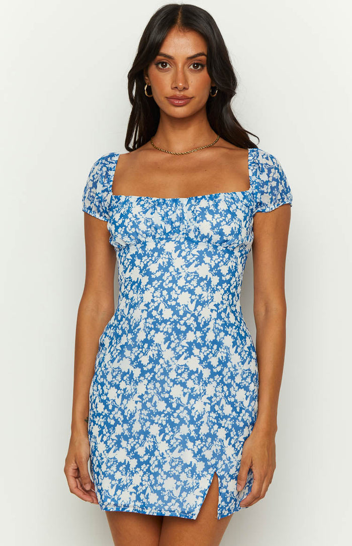 Square neckline and short puff sleeves of a blue floral mini dress with a front thigh slit