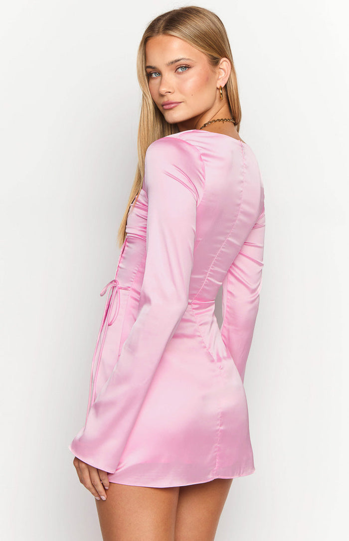 Side view of a pink satin long sleeve mini dress showing the ruched side detail with ties
