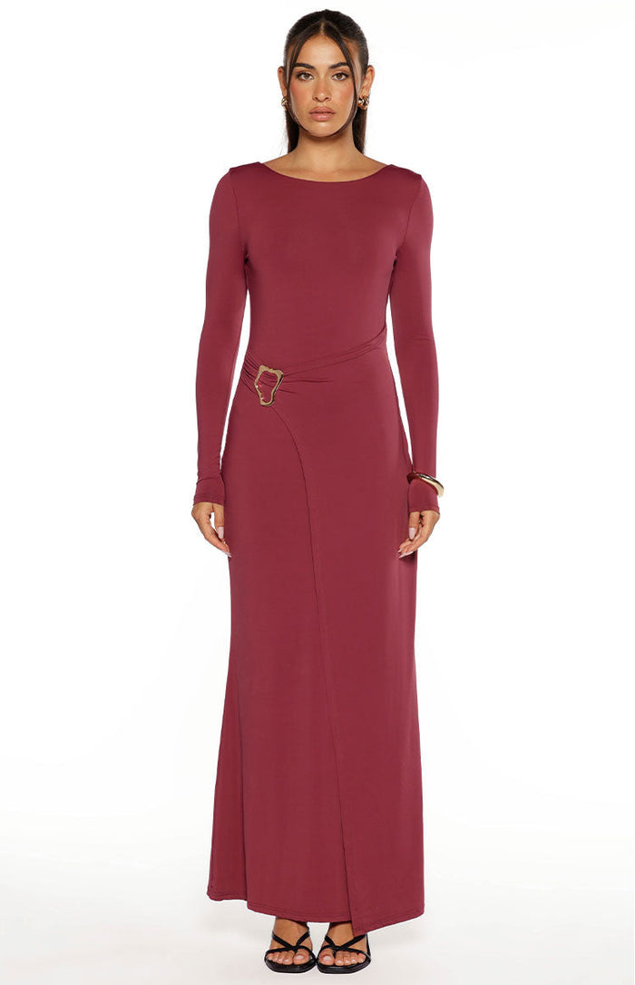 Front view of a burgundy long sleeve maxi dress with a boat neck and a gold buckle detail creating a wrap effect
