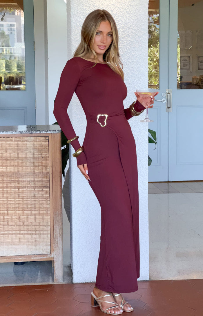 Burgundy long sleeve maxi dress with a gold heart buckle detail at the wrap waist