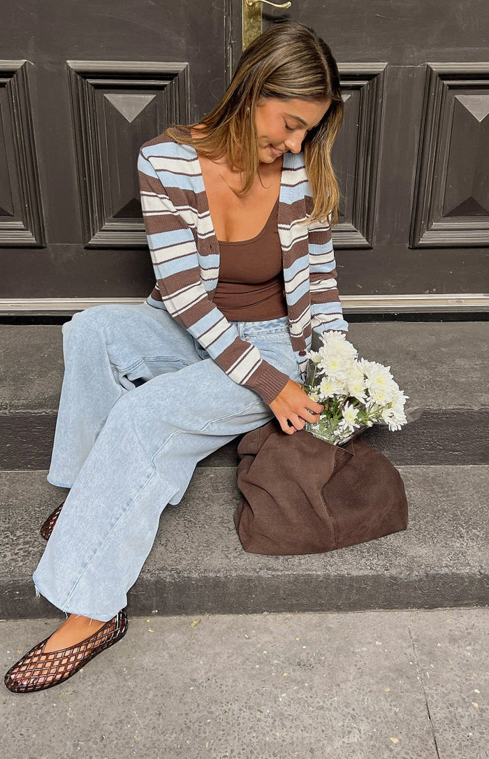 Brown and blue striped cardigan worn open, highlighting the relaxed fit and long sleeves