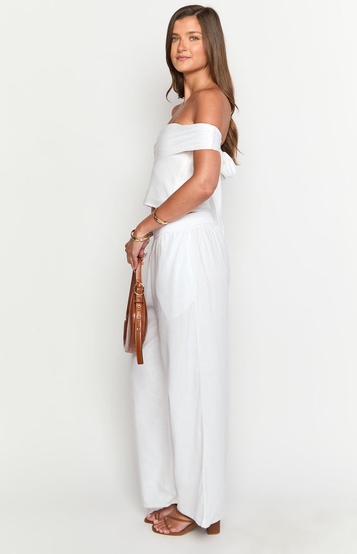 Side view of white wide-leg linen blend pants with a relaxed fit and elasticated high waist