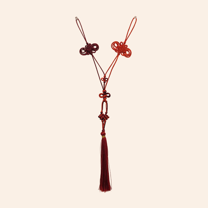 Red tassel with intricate design on a beige background