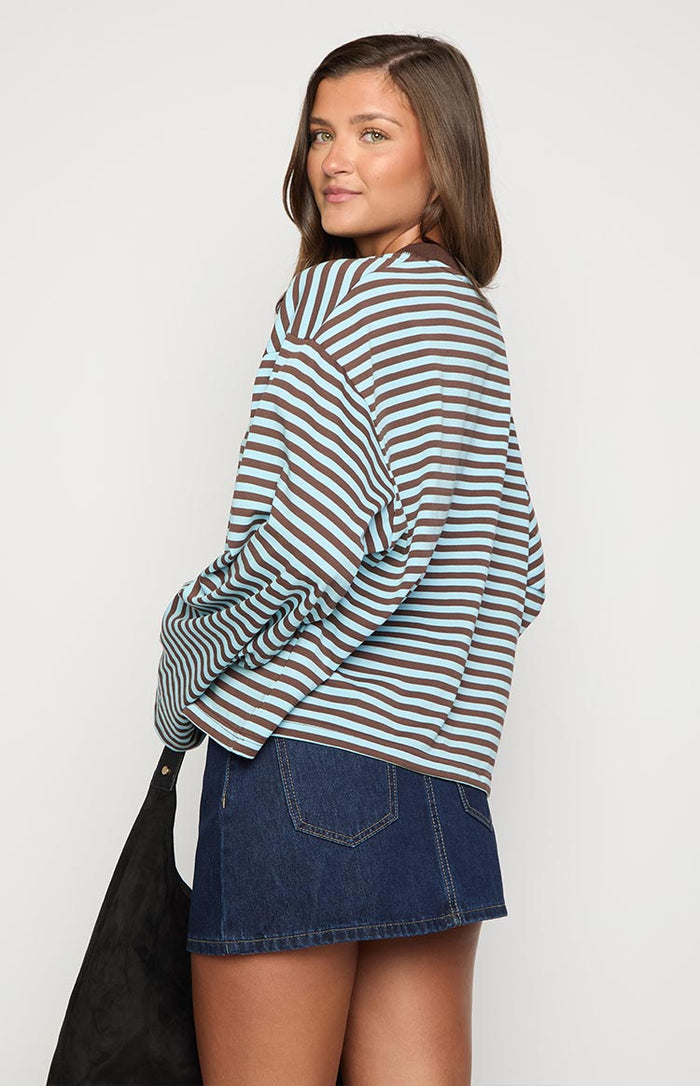 Side view of the dark denim mini skirt, highlighting the back patch pocket and light brown contrast stitching