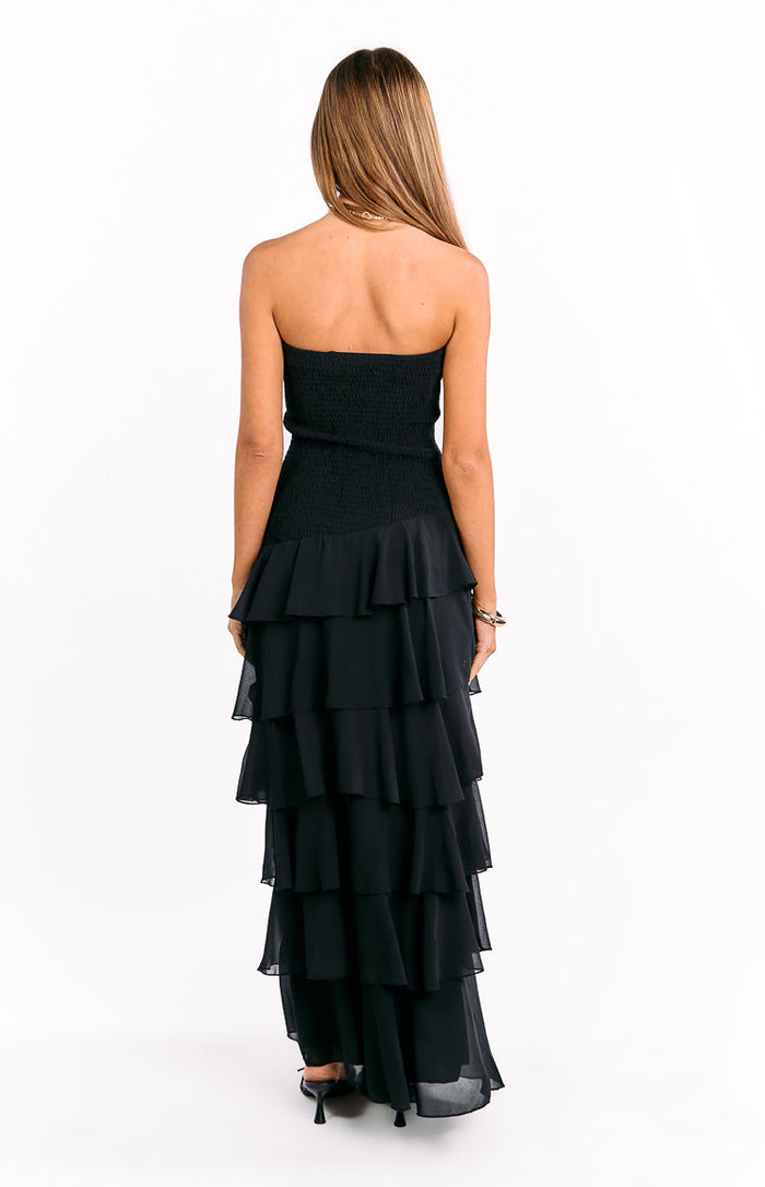 Rear view of a black strapless maxi dress featuring a smocked back bodice and cascading tiered ruffles
