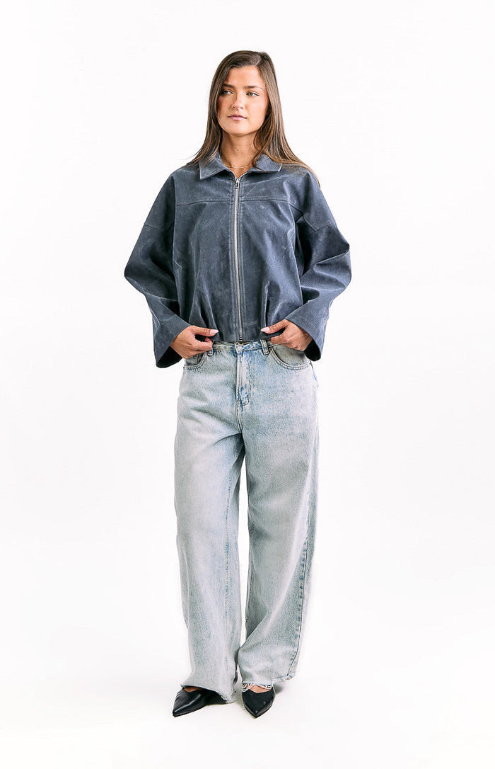 Front view of a steel grey suedette bomber jacket with a full silver zipper, classic collar, wide sleeves, and gathered bubble hem
