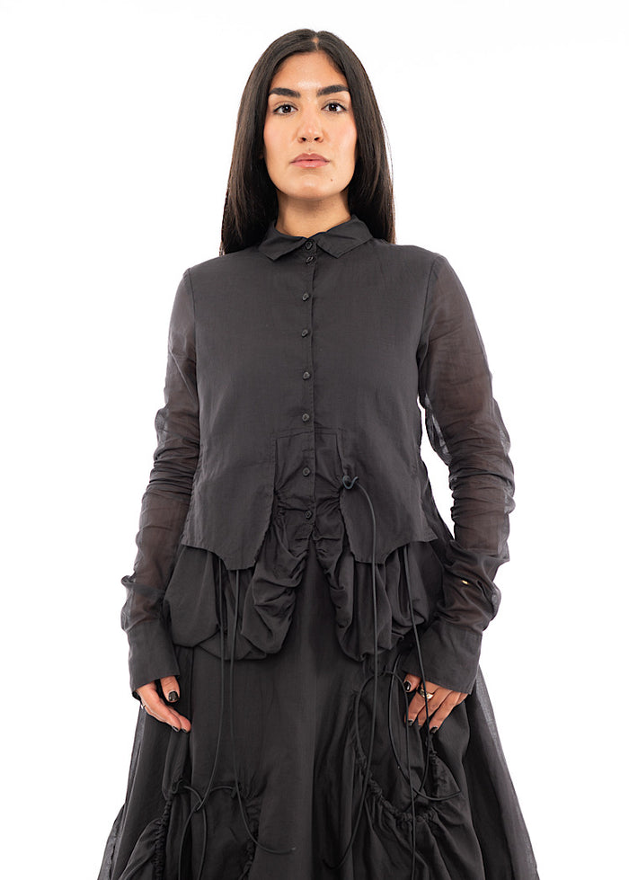 A Model wearing a sculptural  Jacket with a matching Skirt in the same washed Grey colour.