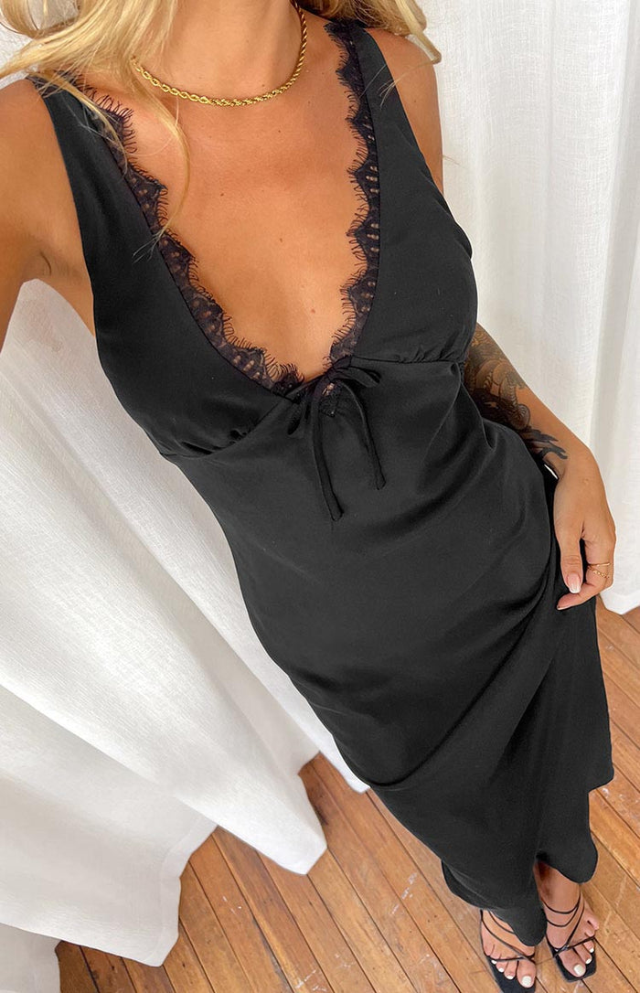 Close-up of the black maxi dress showing the V-neckline with delicate lace trim and a tie detail at the bust