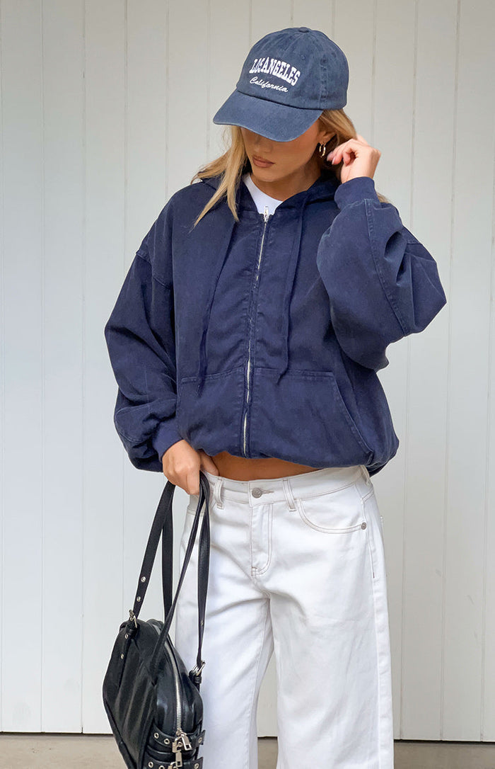Front view of a washed navy oversized hooded jacket with a silver full zip and front pockets